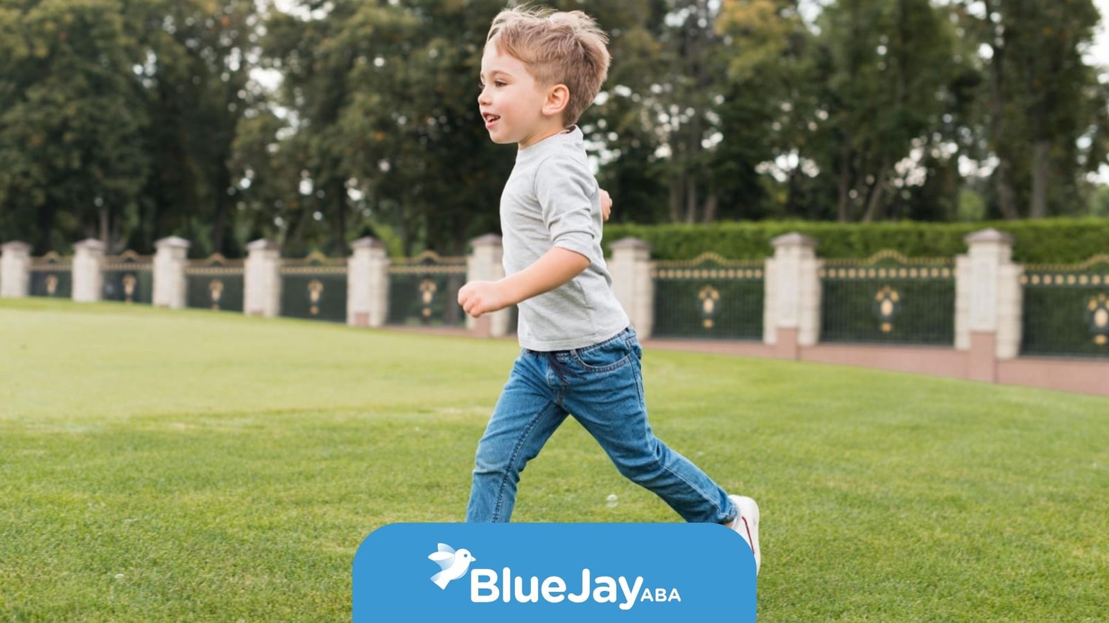 Young boy with autism running across a grassy field outdoors.