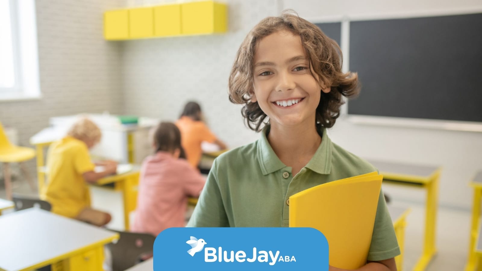 Smiling student holding a yellow folder in a classroom where school-based ABA support may be provided.