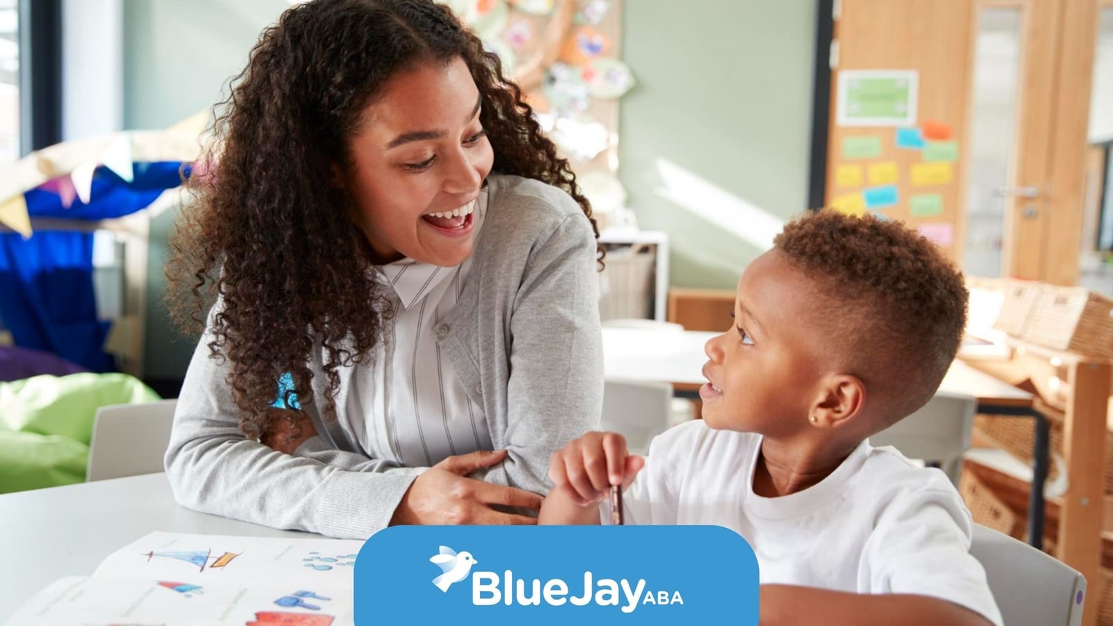 ABA therapist supporting a child during a school-based learning activity.
