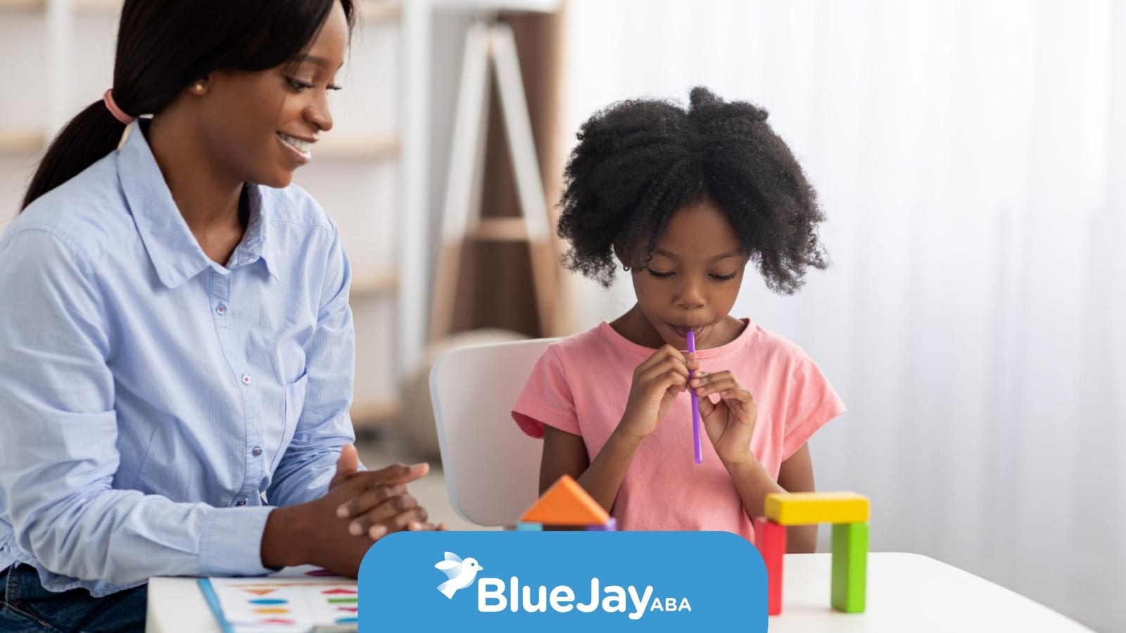 BCBA working with a young child during an ABA therapy activity.