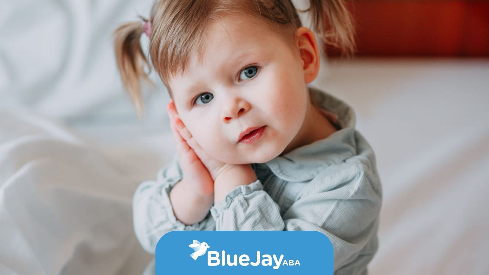 Autistic toddler resting her hands against her cheek.