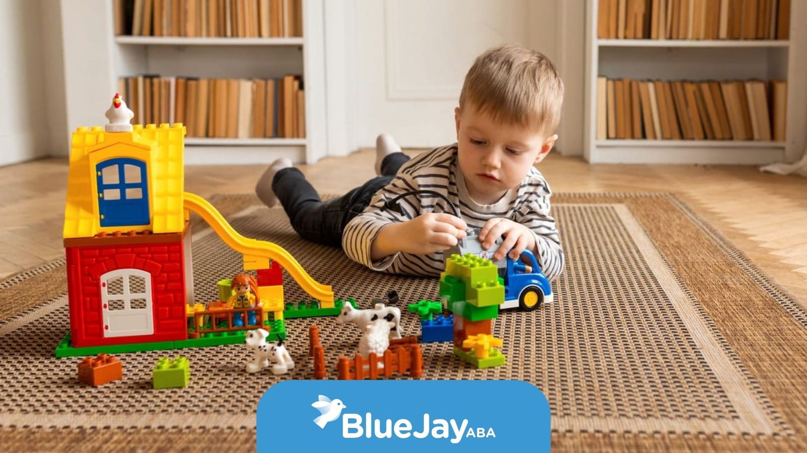 Young child playing with colorful building blocks and toy animals during ABA therapy activity.
