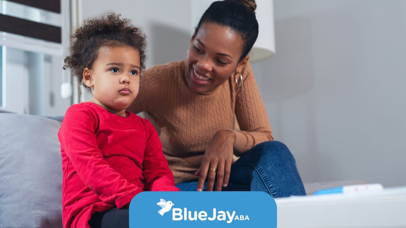 BCBA sitting with a young child during an in-home ABA therapy session.