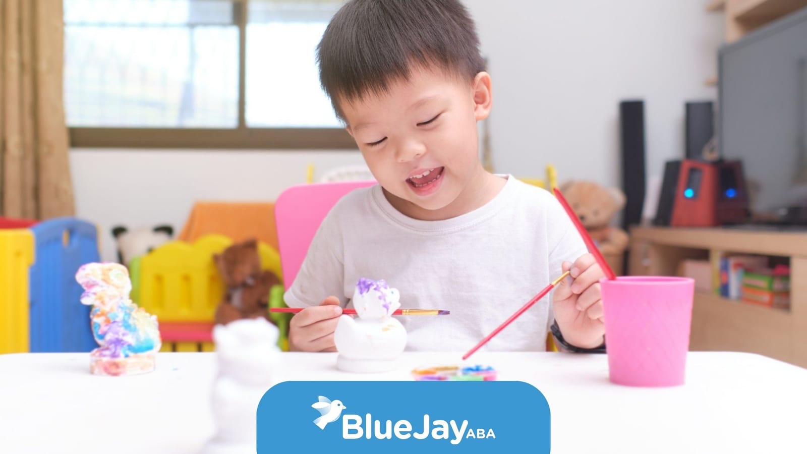 Young boy painting a figurine during a creative learning activity in ABA therapy.