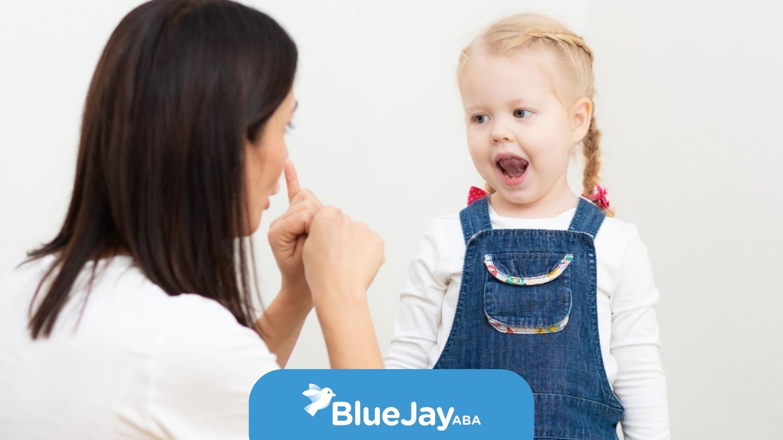 Young child with autism practicing communication skills with a BCBA during an ABA therapy session.