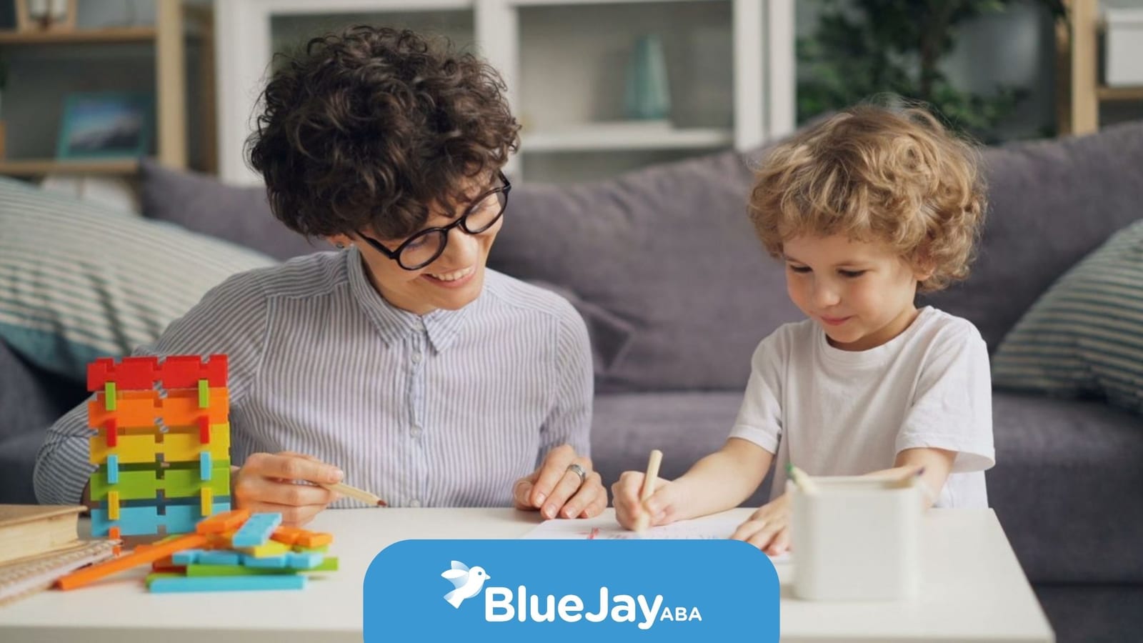 Therapist helping a young child practice drawing and communication skills during an ABA therapy activity.